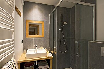A bathroom with a sink a mirror and a shower
