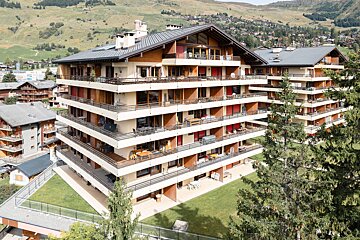 A large apartment building with a mountain in the background