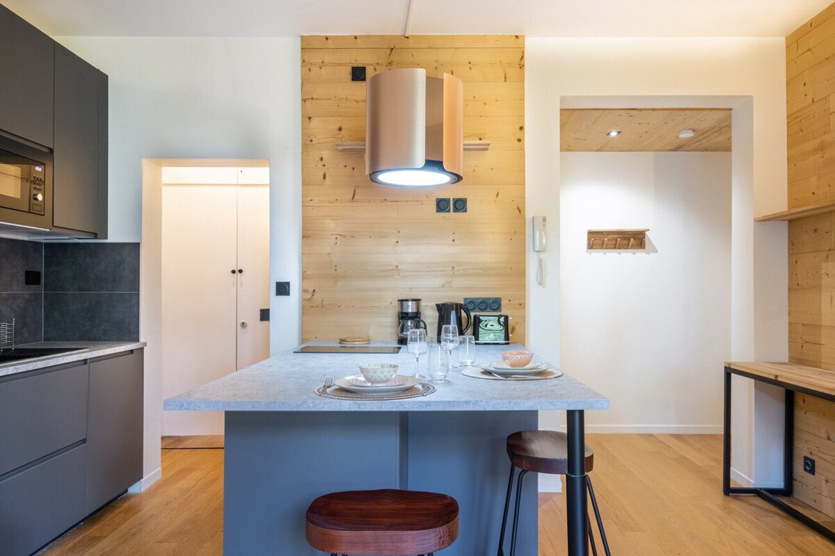 A kitchen with a wooden wall and a table with plates and glasses on it