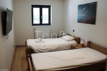 A bedroom with two beds and a painting on the wall that says tengo
