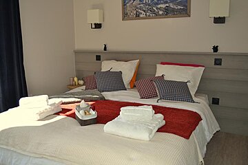 A bed with a basket of towels on it