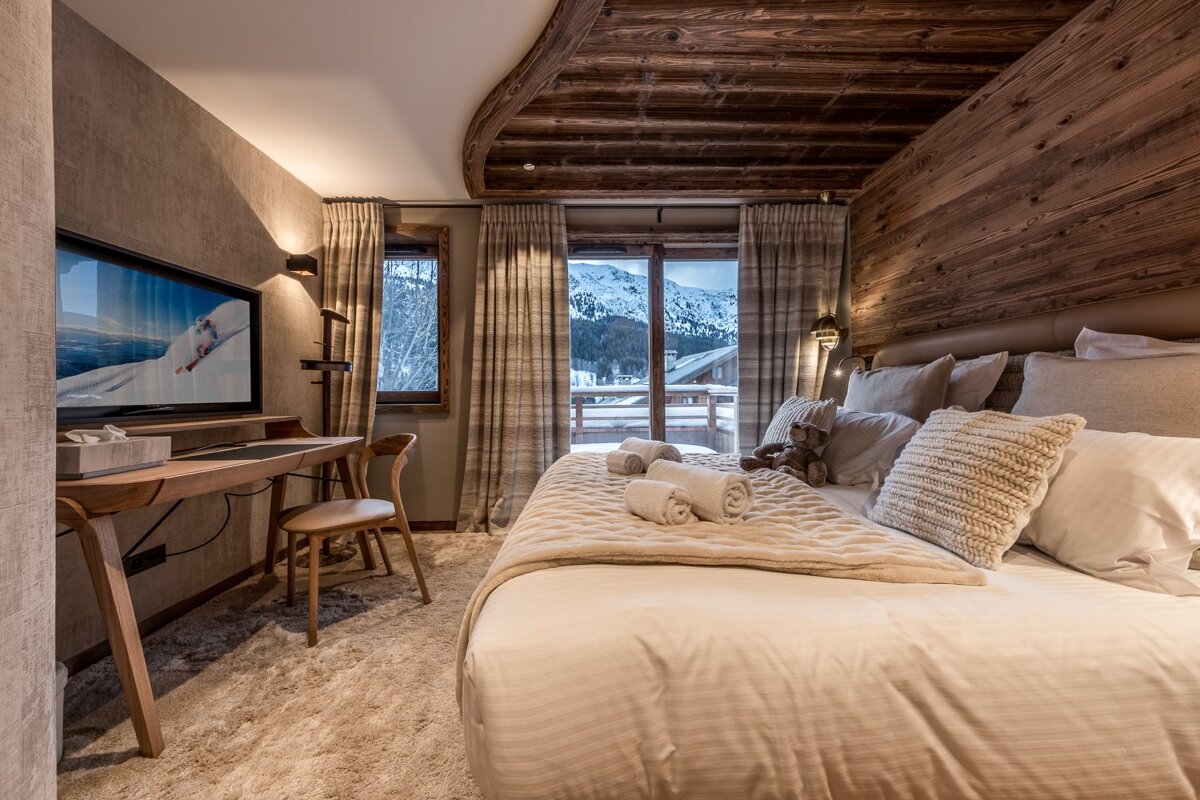 A bedroom with a large bed and a flat screen tv