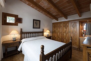 A bedroom with a wooden bed and two lamps