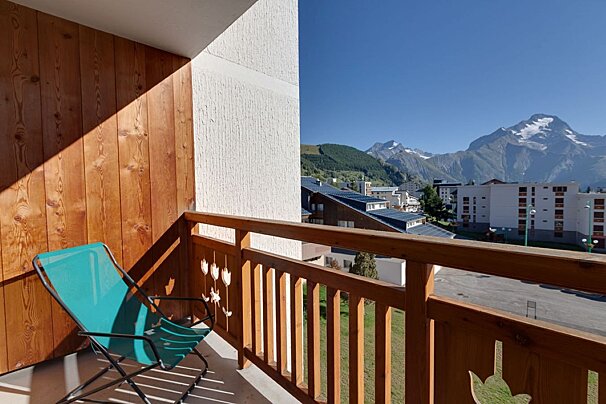 A balcony with a chair and a view of mountains