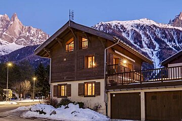 A house with a balcony and a mountain in the background