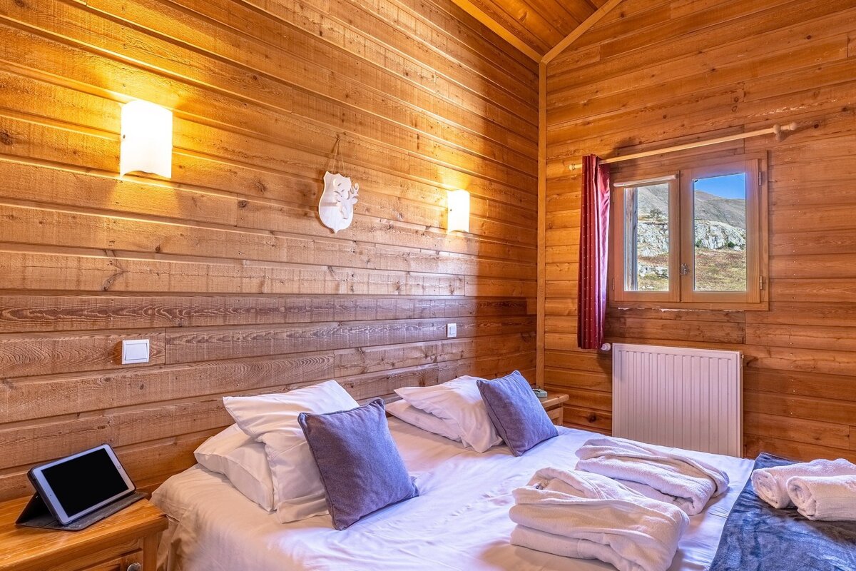 A wooden bedroom with a bed and a window