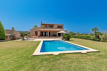 A large house with a large swimming pool in front of it