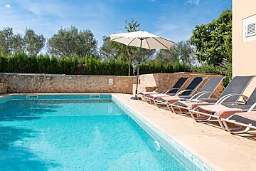 A swimming pool with chairs and a white umbrella