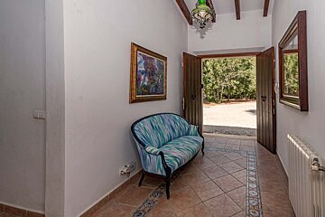 A hallway with a blue couch and a painting on the wall