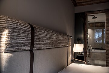 A bedroom with a striped headboard and a lamp