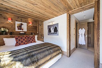 A bedroom with a bed and a picture on the wall