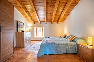 A bedroom with two beds and a wooden ceiling