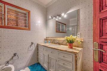 A bathroom with a marble counter top and a mirror