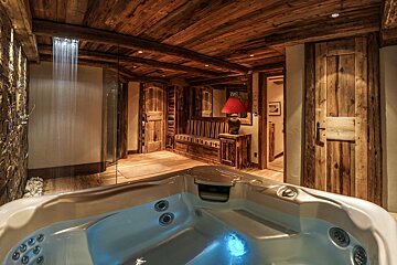 A hot tub in a bathroom with a lamp on a table