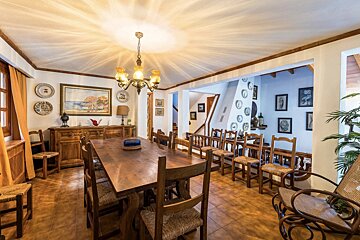 A dining room with a long wooden table and chairs