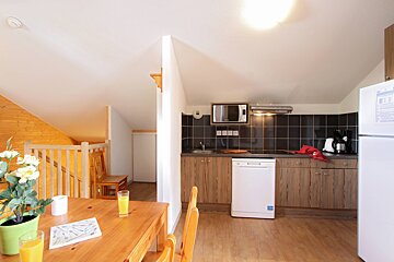 A kitchen with a table and chairs and a dishwasher