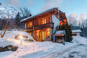 A snowy landscape with a house in the background