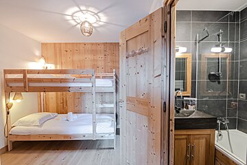 A bedroom with bunk beds and a bathroom with a sink