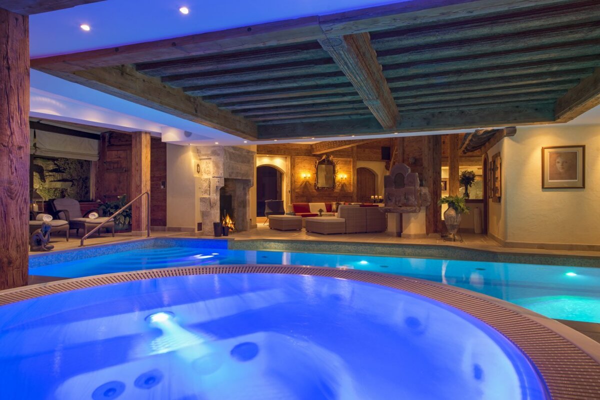 A swimming pool with a jacuzzi in the middle of it