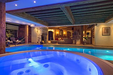 A swimming pool with a jacuzzi in the middle of it