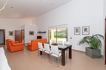 A living room with orange furniture and a dining table