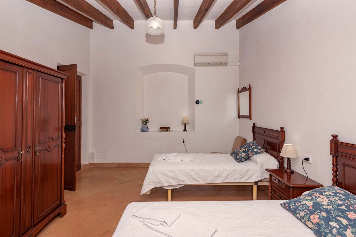 A bedroom with two beds and a mirror on the wall