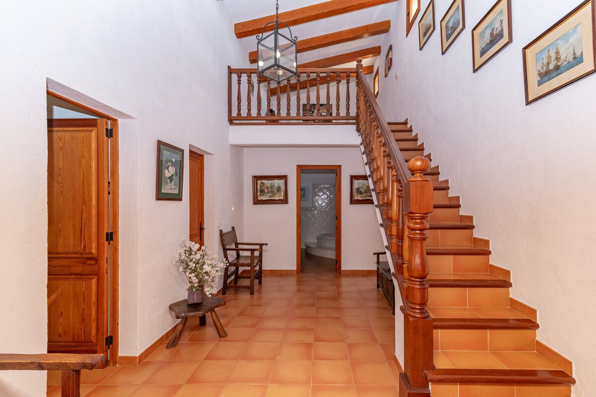A hallway with stairs leading up to the second floor