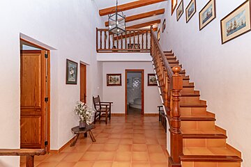 A hallway with stairs leading up to the second floor