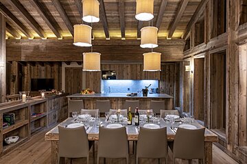 A dining room table with a bottle of wine on it