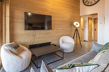 A living room with two chairs and a flat screen tv