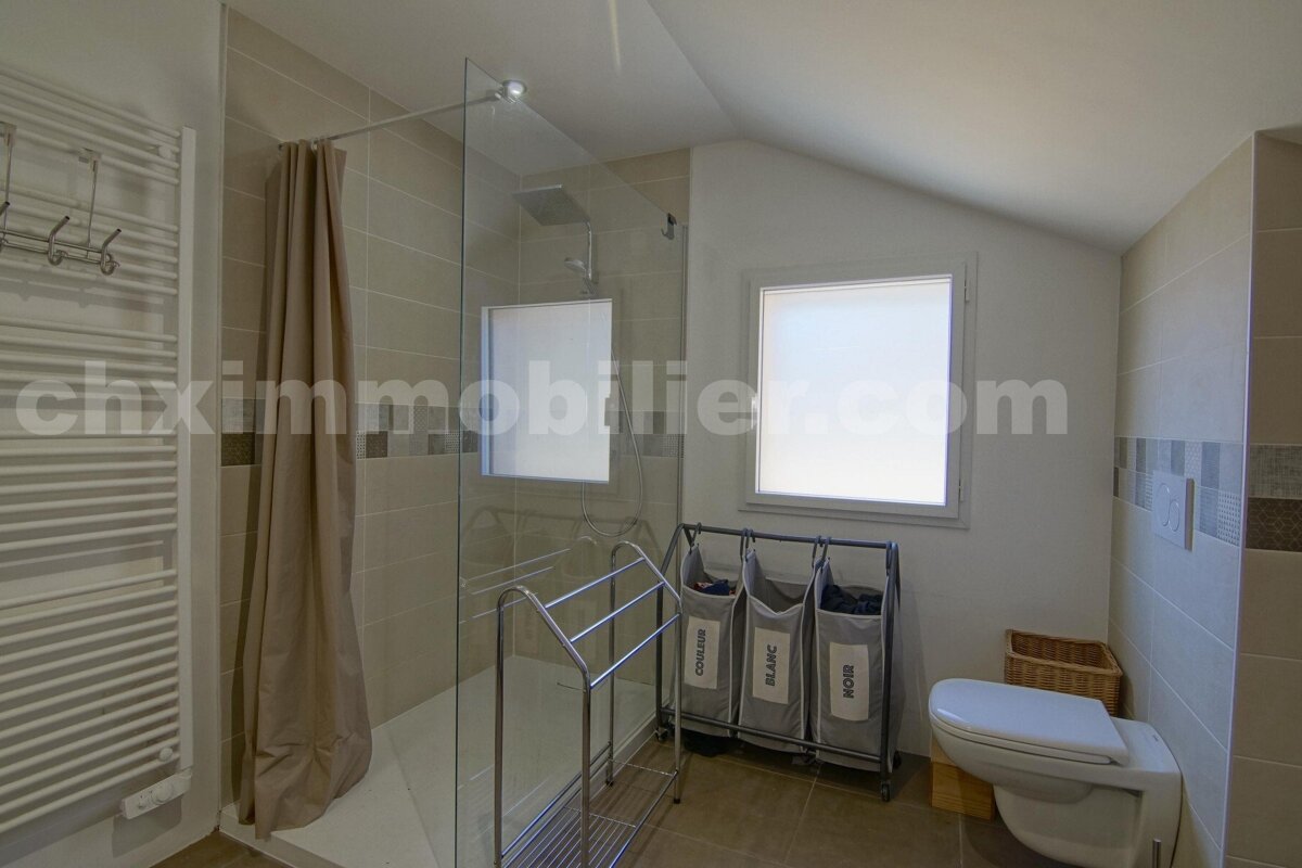 A bathroom with a window and a website called chximmobilier.com