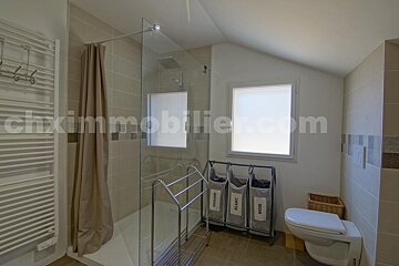 A bathroom with a window and a website called chximmobilier.com