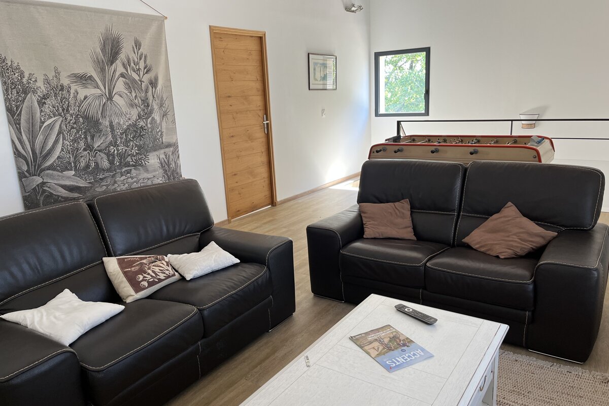 A living room with two couches and a table with a book on it that says sunset