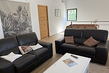 A living room with two couches and a table with a book on it that says sunset