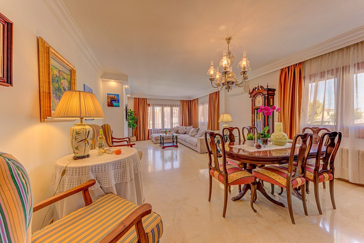 A living room with a table and chairs and a clock