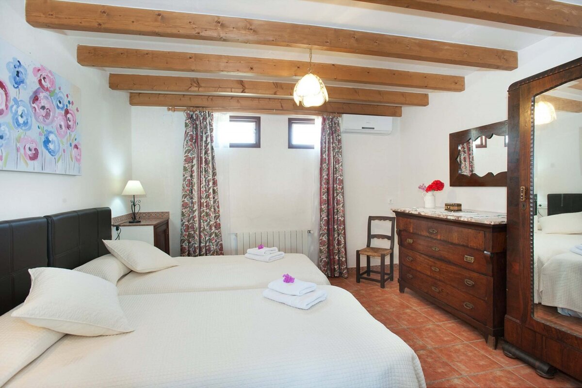 A bedroom with two beds a dresser and a mirror