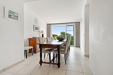 A dining room with a long wooden table and chairs