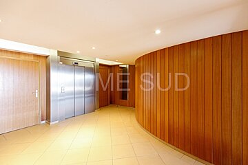 A hallway with elevators and a wall that says home sud