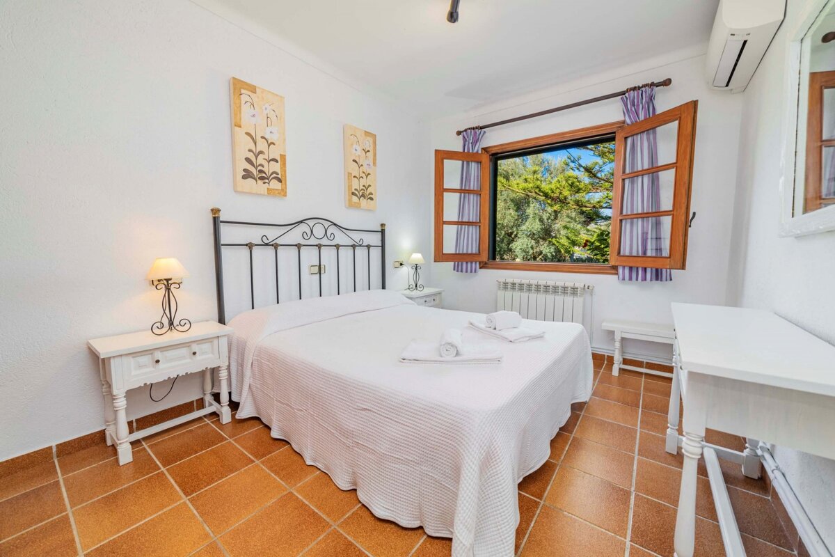 A bedroom with a large bed and a window