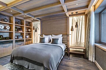 A bedroom with a bed and a window with a picture of trees on it