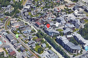 An aerial view of a city shows a train stop and a supermarket