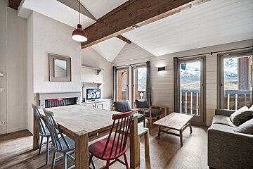 A living room with a table and chairs and a television