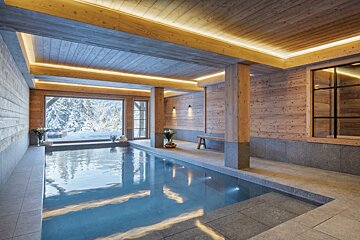 A large indoor swimming pool surrounded by wooden walls