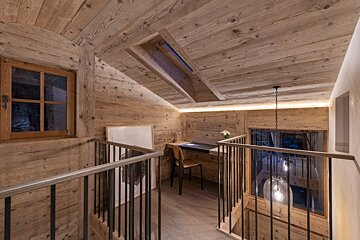 A wooden staircase with a desk in the middle of it
