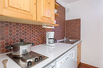A kitchen with a stove top oven and a coffee maker