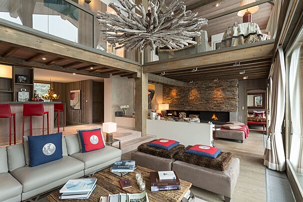 A living room with a couch and ottomans and a table with a book on it that says 