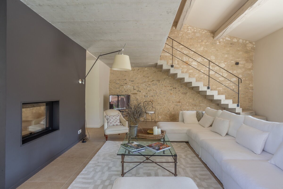 A living room with white furniture and a staircase