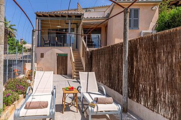 Two lounge chairs are sitting in front of a house