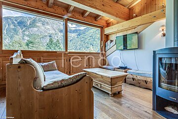 A living room with a couch and a fireplace with the word tenda on the bottom