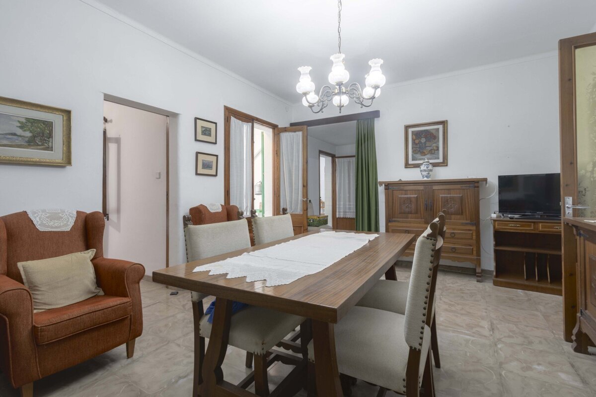 A living room with a dining table and chairs